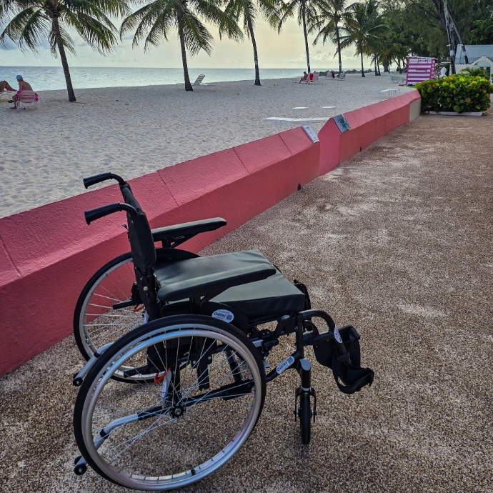 Wheelchair on concrete path by the side beautiful beach